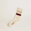 Abgenutzte weisse Socken mit Distressed-Details und beigen sowie burgunderroten Streifen