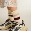 Abgenutzte weisse Socken mit Distressed-Details und beigen sowie burgunderroten Streifen