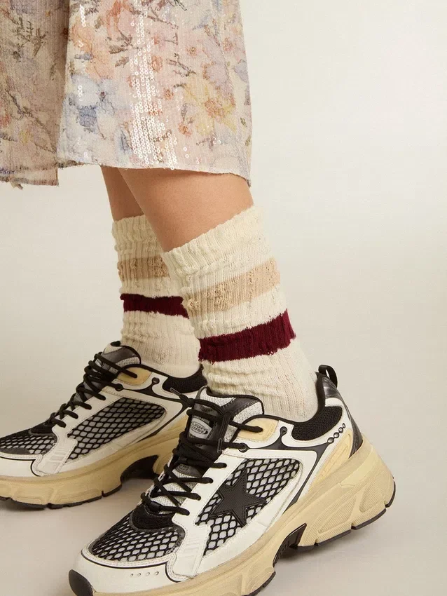 Abgenutzte weisse Socken mit Distressed-Details und beigen sowie burgunderroten Streifen