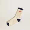 Cremefarbene gerippte Socken mit marineblauen Details und rotem Logo