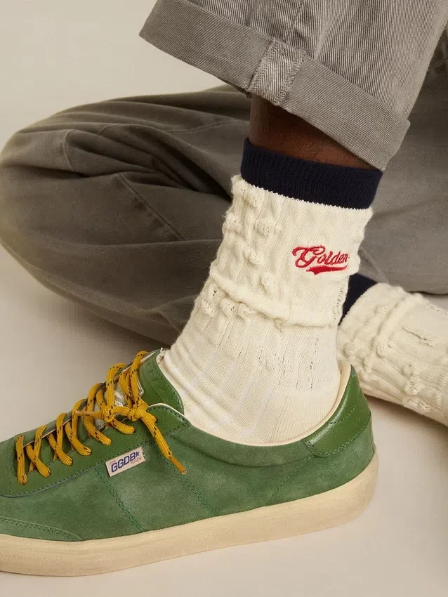 Cremefarbene gerippte Socken mit marineblauen Details und rotem Logo