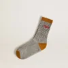 Graue gerippte Socken mit orangefarbenen Details und rotem Logo