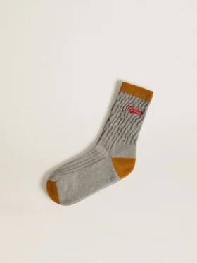 Graue gerippte Socken mit orangefarbenen Details und rotem Logo