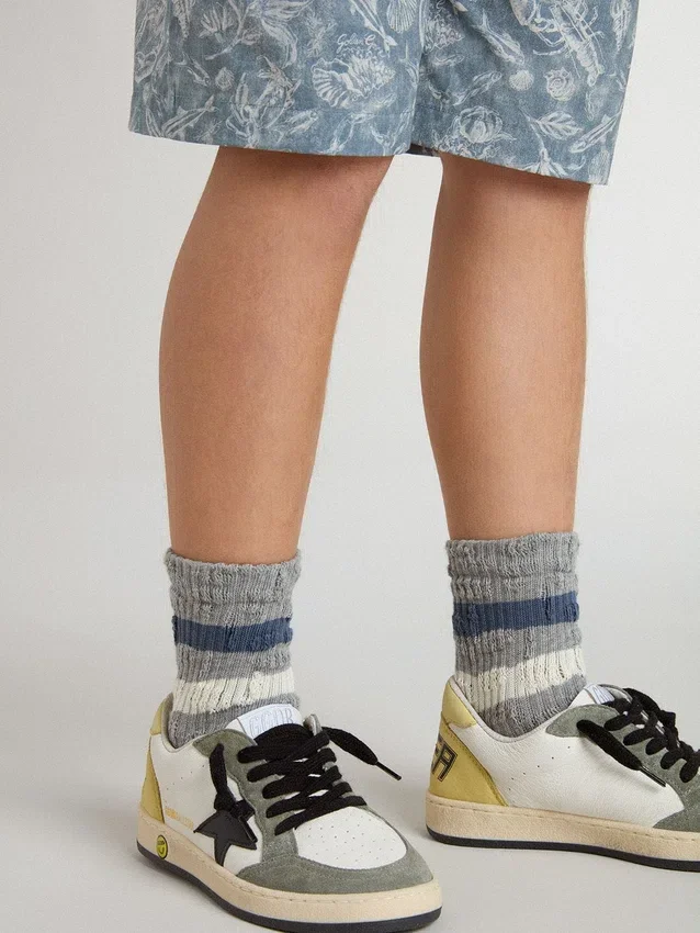 Graue Kindersocken mit Used-Look-Details und abgenutzten weissen und blauen Streifen