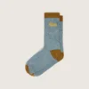 Hellblaue gerippte Socken mit braunen Details und gelbem Logo