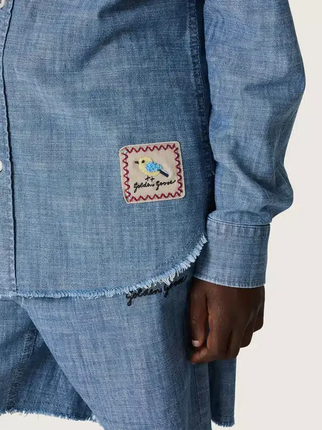 Journey Unisex-Hemd aus hellblauem Baumwoll-Chambray mit Fransen am Saum und gesticktem Aufnäher