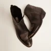 Junge Stiefel aus schwarzem Leder mit sandfarbener Stickerei