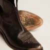Junge Stiefel aus schwarzem Leder mit sandfarbener Stickerei