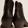 Junge Stiefel aus schwarzem Leder mit sandfarbener Stickerei