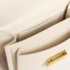Kleine Venezia-Tasche aus butterfarbenem, geprägtem Leder mit geflochtenem Band und doppeltem Anhänger
