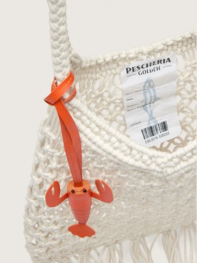 Makramee-Damenhandtasche aus butterfarbener Baumwolle mit einem Lederanhänger in Form einer Hummerklammer