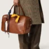 Mittlere Vita-Tasche aus hellbraunem Leder mit Anhängern und silbernen Details