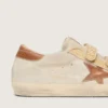 Old-School-Damenschuhe aus perlfarbigem Wildleder mit ziegelrotem Lederstern und Raffia-Riemen