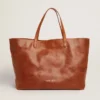 Pasadena-Tasche aus hellbraunem, glänzendem, gehämmertem Leder mit goldenem Logo auf der Vorderseite