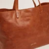 Pasadena-Tasche aus hellbraunem, glänzendem, gehämmertem Leder mit goldenem Logo auf der Vorderseite