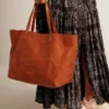 Pasadena-Tasche aus hellbraunem, glänzendem, gehämmertem Leder mit goldenem Logo auf der Vorderseite