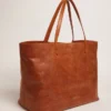 Pasadena-Tasche aus hellbraunem, glänzendem, gehämmertem Leder mit goldenem Logo auf der Vorderseite