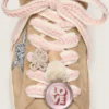 Schnürsenkel aus Lederwaren in Hellbeige mit rosa Zierflechtung, Anstecknadel und Applikationen