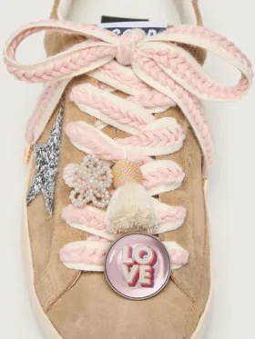 Schnürsenkel aus Lederwaren in Hellbeige mit rosa Zierflechtung, Anstecknadel und Applikationen