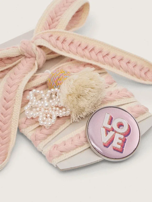 Schnürsenkel aus Lederwaren in Hellbeige mit rosa Zierflechtung, Anstecknadel und Applikationen