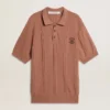 Ziegelrotes Herren-Polo mit gesticktem Logo.