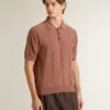 Ziegelrotes Herren-Polo mit gesticktem Logo.